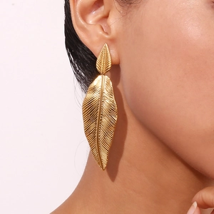 18K gold plated stainless steel layered feather leaf earrings worn on model's ear