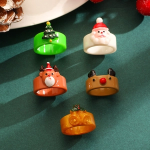 Detailed view of Christmas ring set featuring Santa Claus, reindeer, and tree on green background