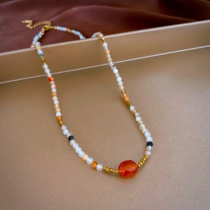 Macro detail of agate bead necklace featuring gold-plated spacers and natural minerals
