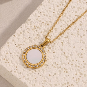 Macro shot of 18K gold plated necklace featuring a round shell pendant with crystal halo