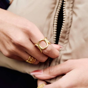 Irregular geometric hollow gold stainless steel ring worn on hand with minimalist design