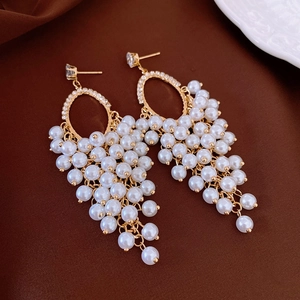Detailed macro view of elegant gold tassel earrings with pearls and rhinestones