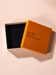 Macro shot of minimalist orange and white jewelry gift box with textured paper finish