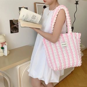 Detail of pink and white bubble texture fabric on a large canvas tote bag shoulder strap
