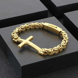 Detailed macro view of gold Byzantine chain bracelet with a polished cross centerpiece
