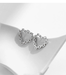 Detailed view of silver heart-shaped stud earrings with chain texture on a white base