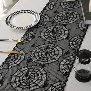Halloween black lace table runner featuring spider web designs on a festive dining table