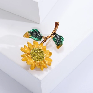 Detailed view of yellow enamel sunflower brooch with rhinestones on a white stand