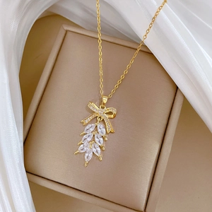 Elegante goldene Titankette mit Schleifenanhänger und funkelnder Zirkonia-Quaste