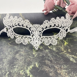 Detailed texture of white lace masquerade mask with intricate hollow patterns and side ties