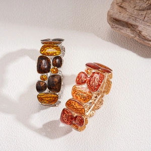 Bohemian geometric resin bracelets with gold and silver elastic bands on white marble background