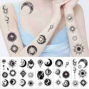 Detail of sun and moon temporary tattoo stickers on arm and multiple design sheets