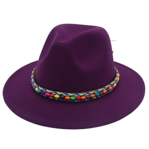 Détail d'un chapeau fedora violet foncé avec ruban tissé ethnique et perles colorées
