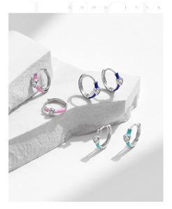 Detail of silver S925 hoop earrings with heart-shaped zircon and colorful enamel accents