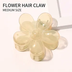 Detail of candy-colored flower hair claw in translucent yellow with metallic spring
