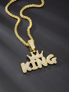 Macro detail of gold rope chain necklace with iced out KING crown pendant and crystals