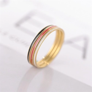 Detail of a gold titanium ring featuring black, red, and white enamel stripe accents