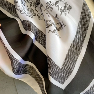 Close-up of black and white silk scarf with vintage sketch pattern and soft texture