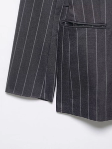 Detail of dark grey pinstripe blazer showing cuff stitching and textured fabric