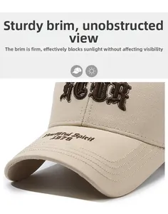 Close-up of the beige baseball cap showing 3D brown embroidery and twill fabric texture