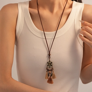 Detail of bohemian long tassel necklace with vintage metal flowers and brown beads