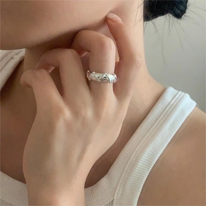 Detail of S925 sterling silver ring with geometric triangle texture on index finger