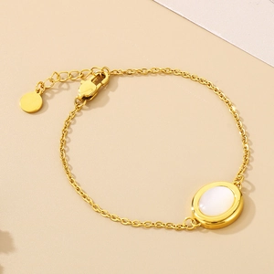 Macro view of gold chain bracelet featuring an oval white opal stone and extension link