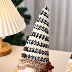 Detailed view of coffee gnome with black striped knit hat and festive red satin bow