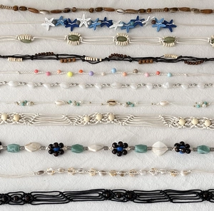 Detail of Bohemian woven waist ropes with wooden beads and seashells for beach style