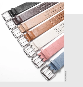 Detail view of colorful faux leather punk belts with star studs and metal buckles
