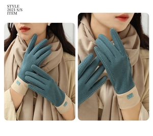 Detailed close-up of teal winter gloves featuring warm plush cuffs and fashion label