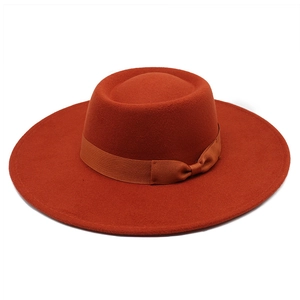 Détail du chapeau en laine couleur rouille avec large bord et ruban élégant à nœud plat