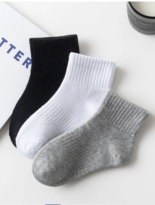 Detail of ribbed knit cotton socks in white, black and grey on minimalist background