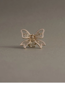 Detailed macro view of the gold butterfly hair claw clip with elegant pearl embellishments