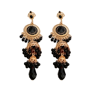 Vintage golden Jhumka earrings with black crystals and water drop tassels on white background