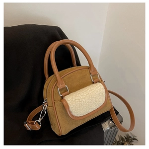 Detailed view of brown faux suede handbag with white faux shearling pocket and PU leather handles