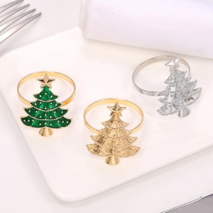 Macro shot of three festive Christmas tree napkin rings in green, gold, and silver finishes