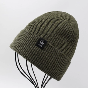 Dettaglio del berretto in maglia a coste verde militare con trama in lana e patch