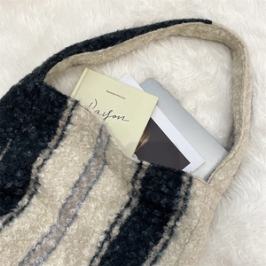 Detail of wool-like striped tote bag showing large capacity for books and tablets