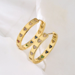 Chic 18K gold plated hoop earrings with colorful zircon heart charms on white fabric