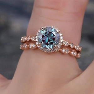 Detail of rose gold bridal ring set featuring a round teal gemstone and marquise band