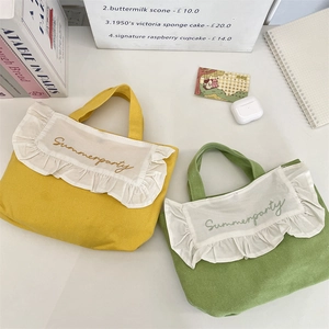 Close-up of canvas lunch bags with ruffled edges and Summerparty floral embroidery