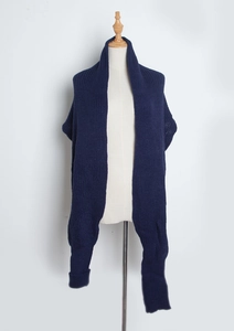 Detailed texture of navy blue knit scarf wrap with integrated sleeve design on mannequin