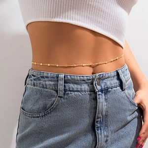 Close-up of golden multi-layer belly chain with small square beads on model waist