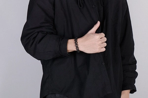 Close-up of industrial style black titanium steel skull chain bracelet worn by a model