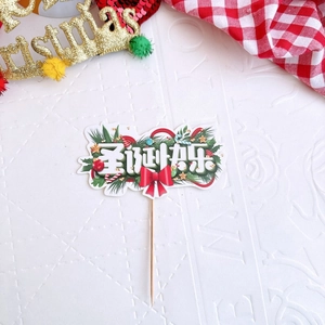 Detail of Christmas cake topper with festive bow and Merry Christmas text in artistic font