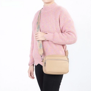 Dettaglio della borsa a tracolla in pelle beige con ampia tracolla in tessuto jacquard