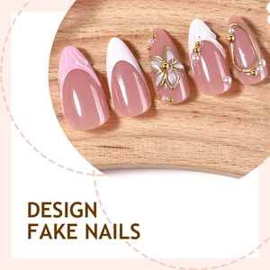 Faux ongles amande 3D avec fleurs, French manucure et perles sur plateau en bois