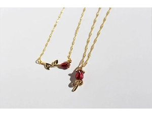 Close-up of vintage red enamel rose pendant necklace with gold-plated brass chain