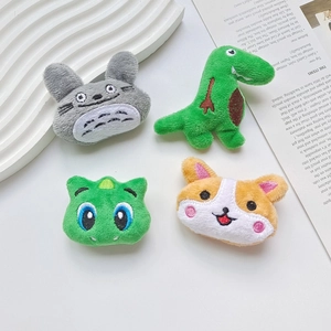 Cartoon plush brooches featuring dinosaur and corgi on a white decorative tray